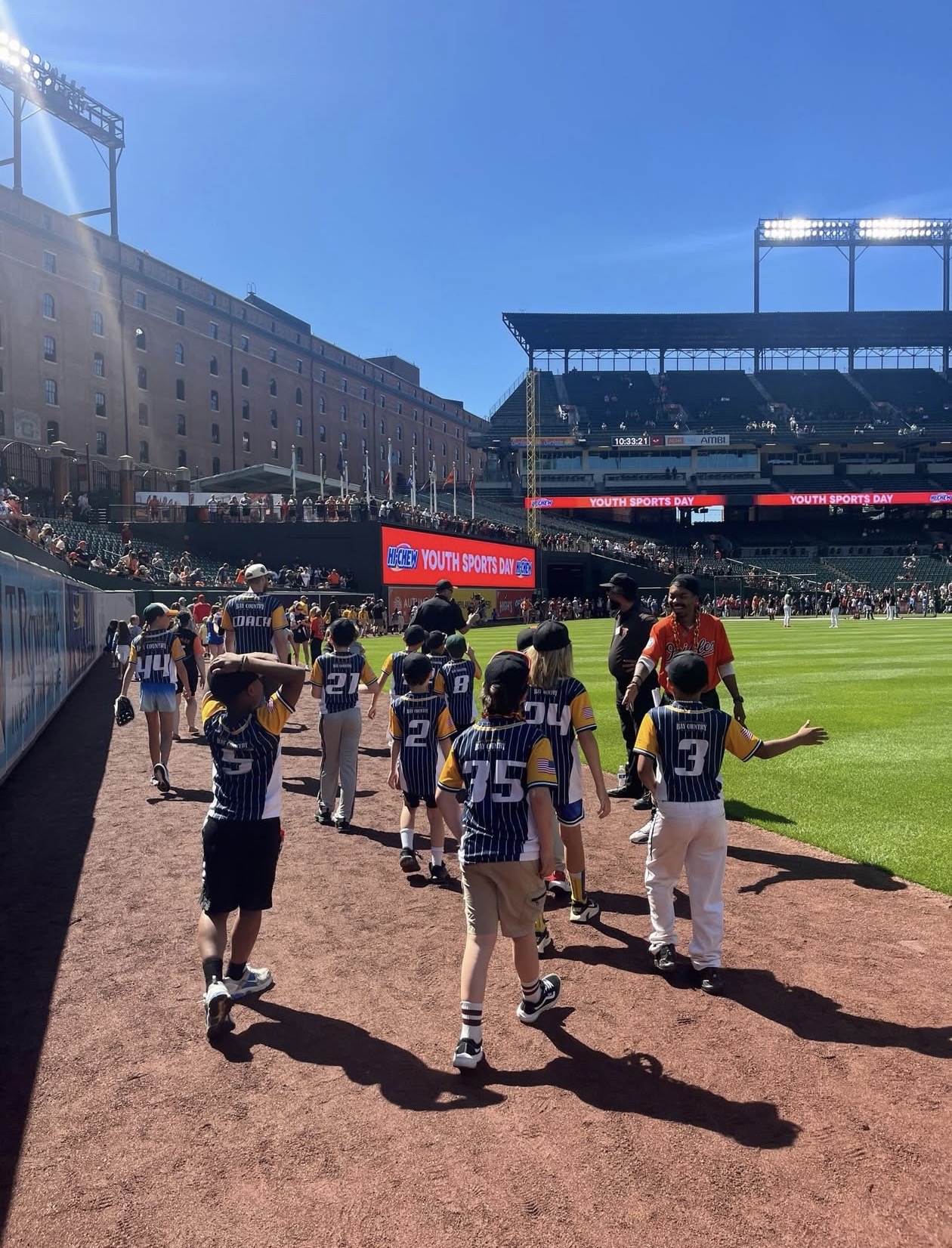 Reisterstown Baseball players walking onto the field for Orioles Youth Sports Day